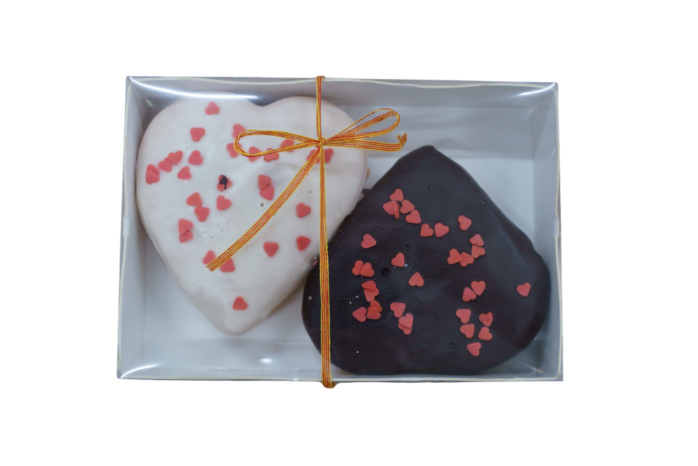 Caixa rectangular amb dues berlines en forma de cor. Una de xocolata negre i l'altre de xocolata blanca i maduixa.